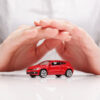 Hands Creating Protective Shield Over Small Car — Lakeland, FL — Family Insurance Centers